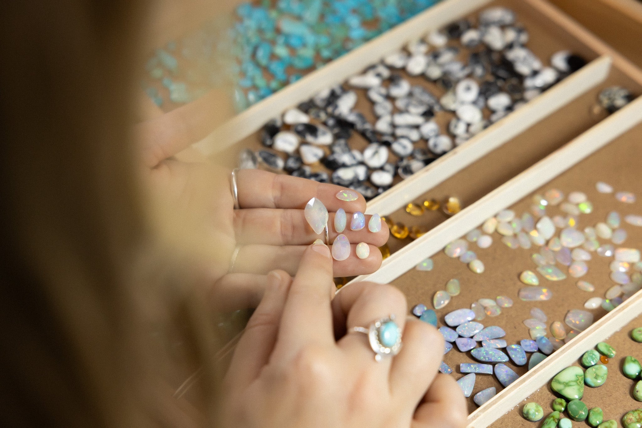 hand selecting natural opal stone for jewelry 